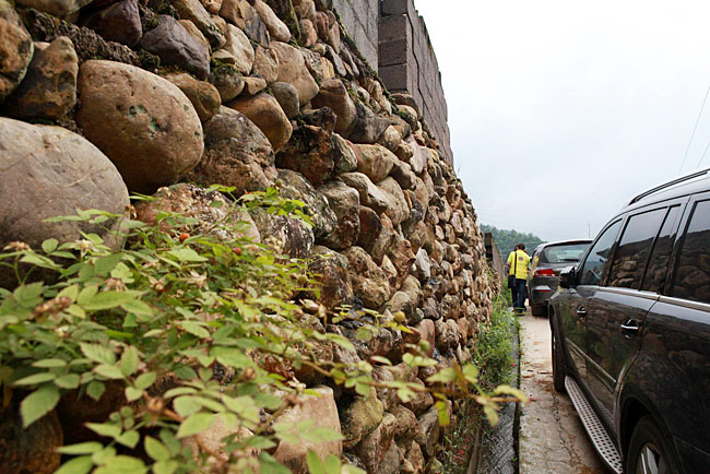 油石鄉(xiāng)梅嶺小學(xué)路口較窄,車(chē)隊(duì)只能停在路邊,步行上去